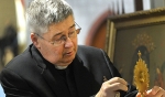 Father Michael Burzynski, pastor of St. John Gualbert, looks over a relic in the relic chapel. (Dan Cappellazzo/Staff Photographer)